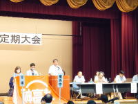 4年ぶりの通常開催となった定期大会の開会にあたり挨拶をする佐藤委員長の様子
